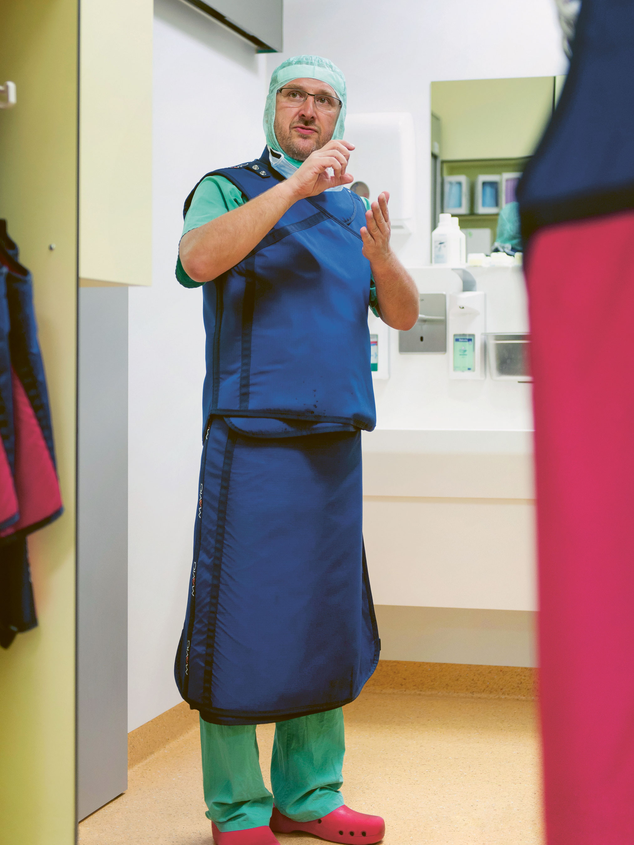 Surgeon Dr. Sven Seifert stands in a hallway briefing his team.