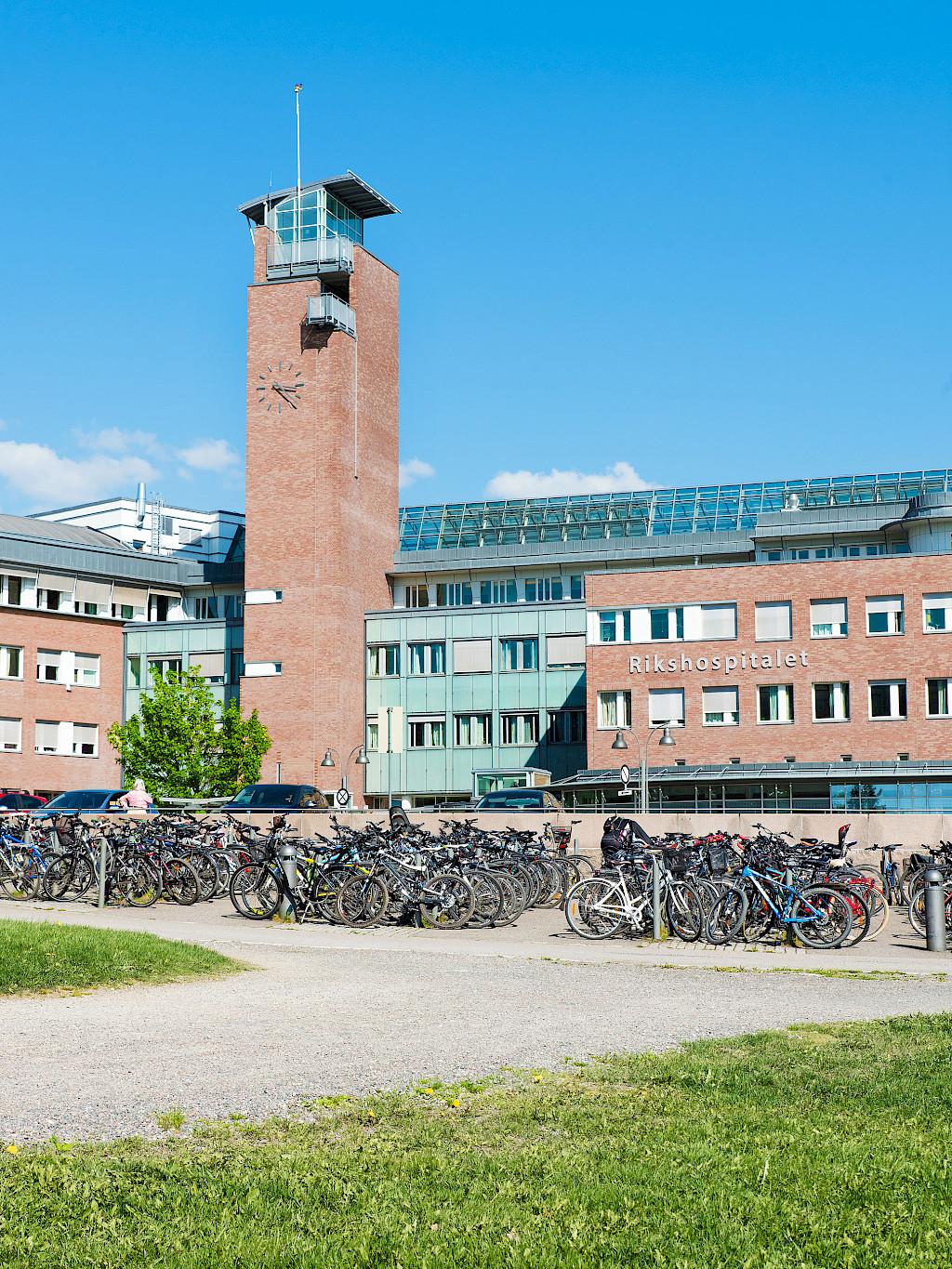 Das Rikshospitalet in Oslo mit einem überfüllten Fahrradabstellplatz im Vordergrund.