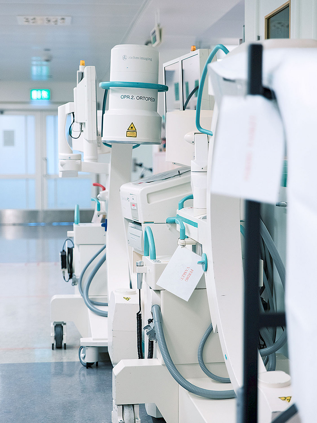Mobile C-arms stand in a hospital corridor