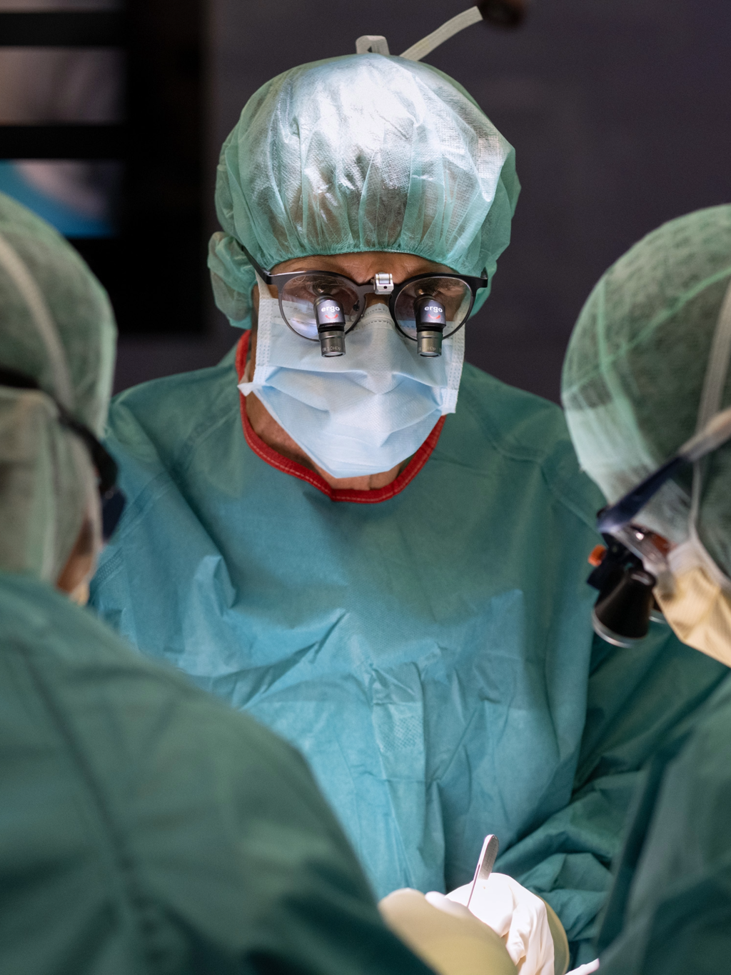 Through his magnifying glasses, Prof. Schweizer closely monitors the removal of the benign cartilage tumor from the patient’s ring finger.